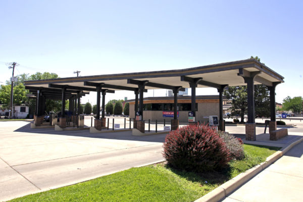 An exterior photo of a bank showing drive-up atms and tellers